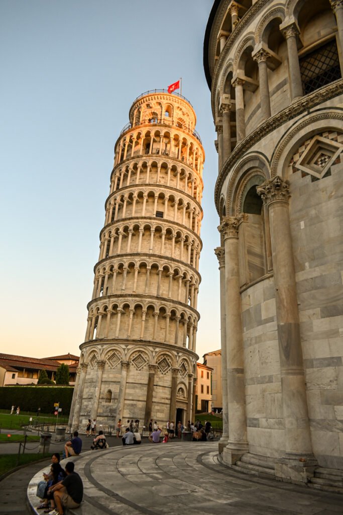 Historischer schiefer Turm in Pisa, Italien, bei Sonnenuntergang, voller Touristen, als ikonisches Symbol der Stadt.