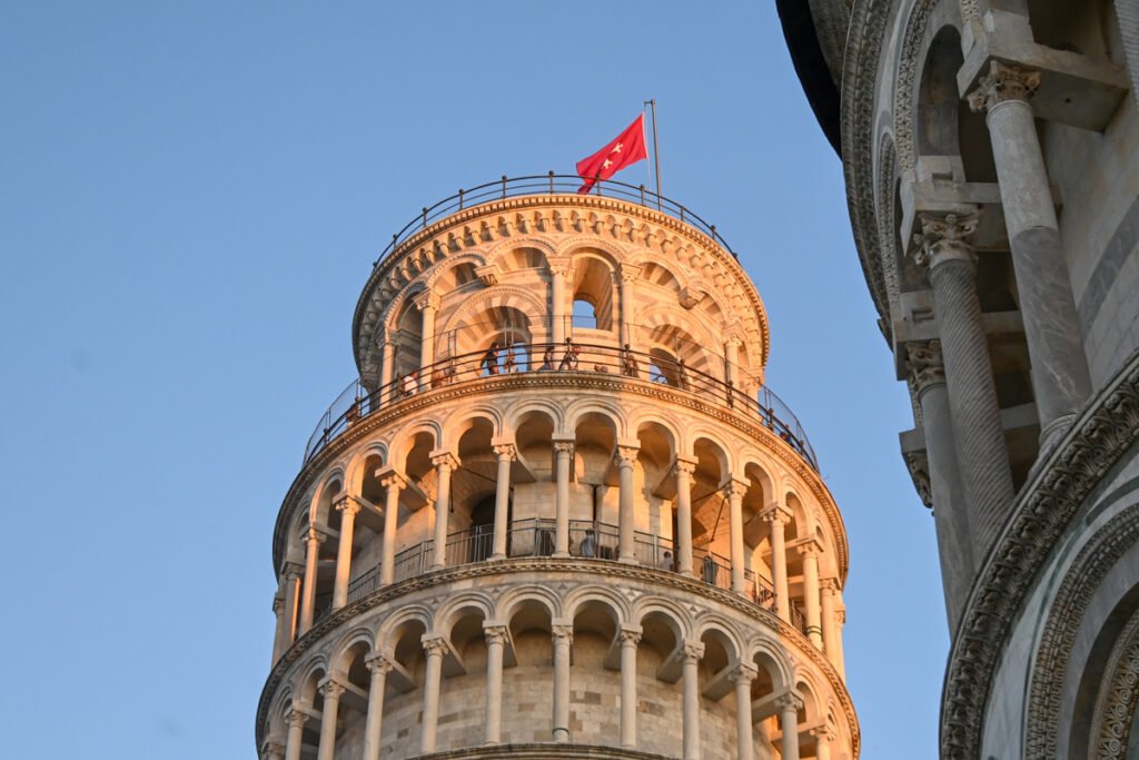 Bischofsturm in Pisa bei Sonnenuntergang, bekannte Touristenattraktion und Wahrzeichen der italienischen Stadt, faszinierende Architektur mit zahlreichen Säulen und Details, ideal für Reisefotos.
