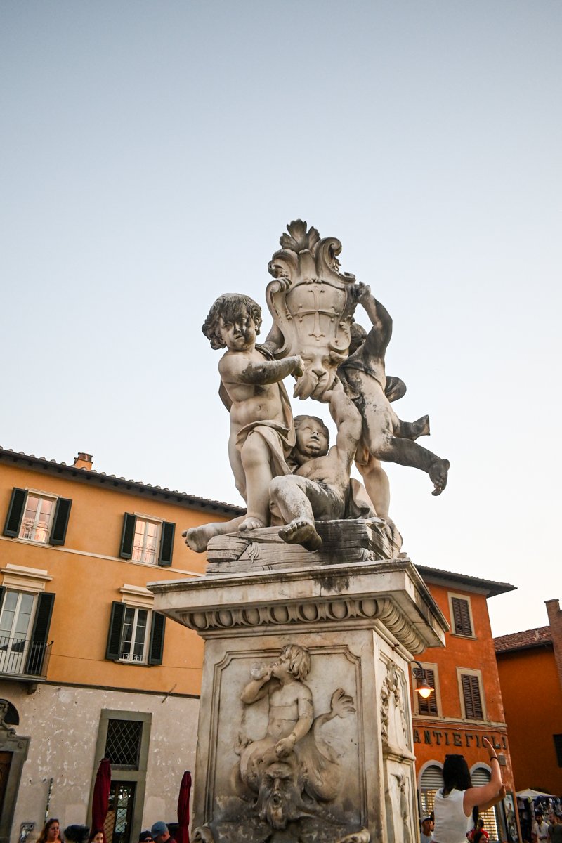 Historische Barockbrunnen Skulptur in der Altstadt von Rom, detailreiche Marmorfigur mit Putten und Wasserhasen, Touristen fotografieren beeindruckendes Stadtmuseum in Italien, Kunst des 17. Jahrhunderts, beliebtes Fotomotiv.